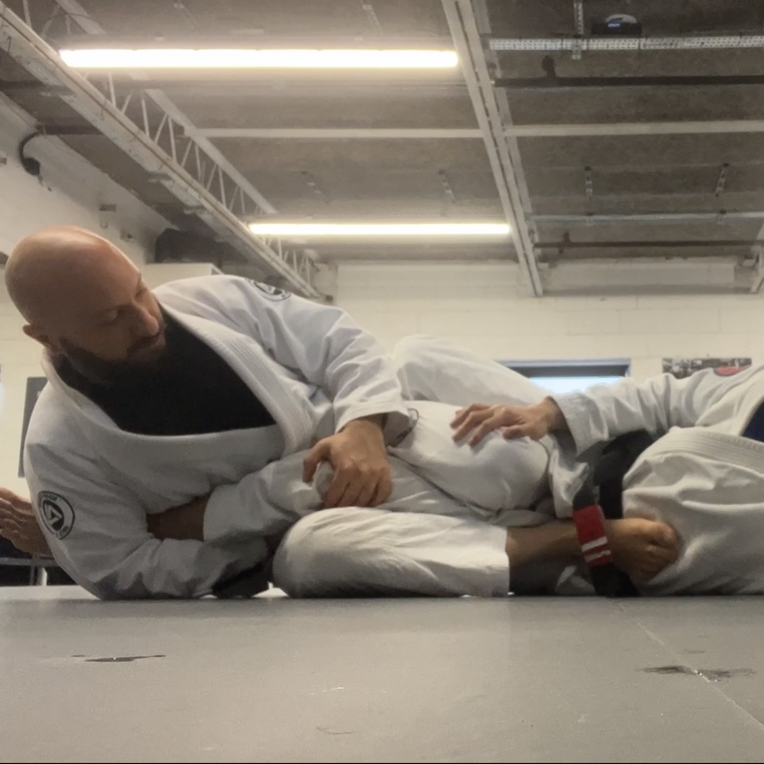Olgun Tiltay learning ashi garami from Chris Ong [2nd Dan] BJJ Coach at Roger Gracie Academy